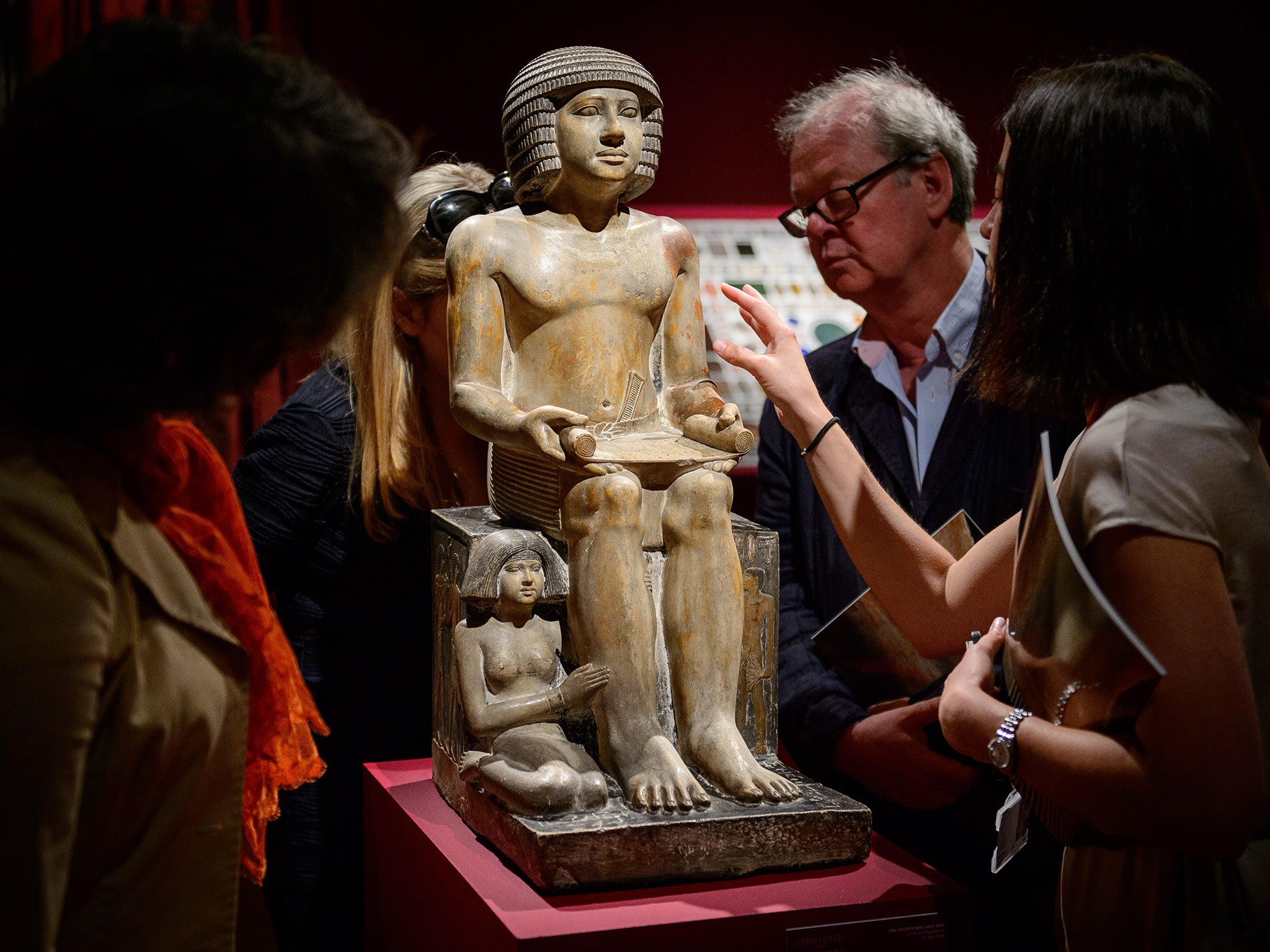 Members of the public and gallery staff examine The Northampton Sekhemka, an Egyptian painted limestone statue