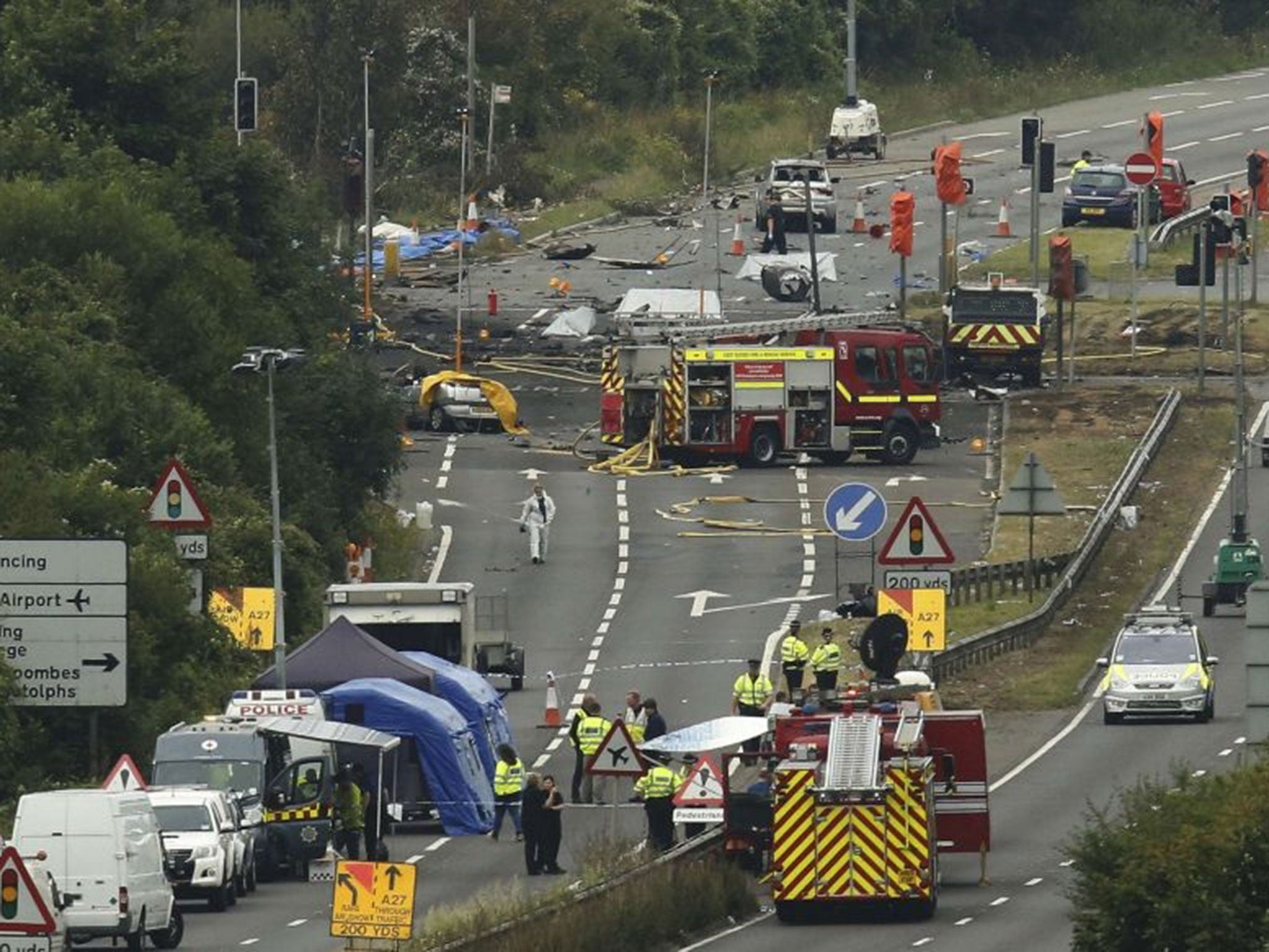 Emergency services and crash investigation officers work at the site where a Hawker Hunter fighter jet crashed onto the A27 road at Shoreham near Brighton