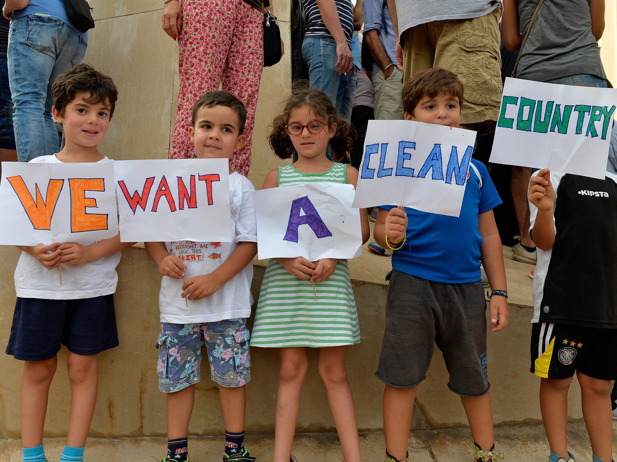 Lebanese children carry placards during a protest against the ongoing garbage crisis, near the Lebanese Government Palace at downtown Beirut