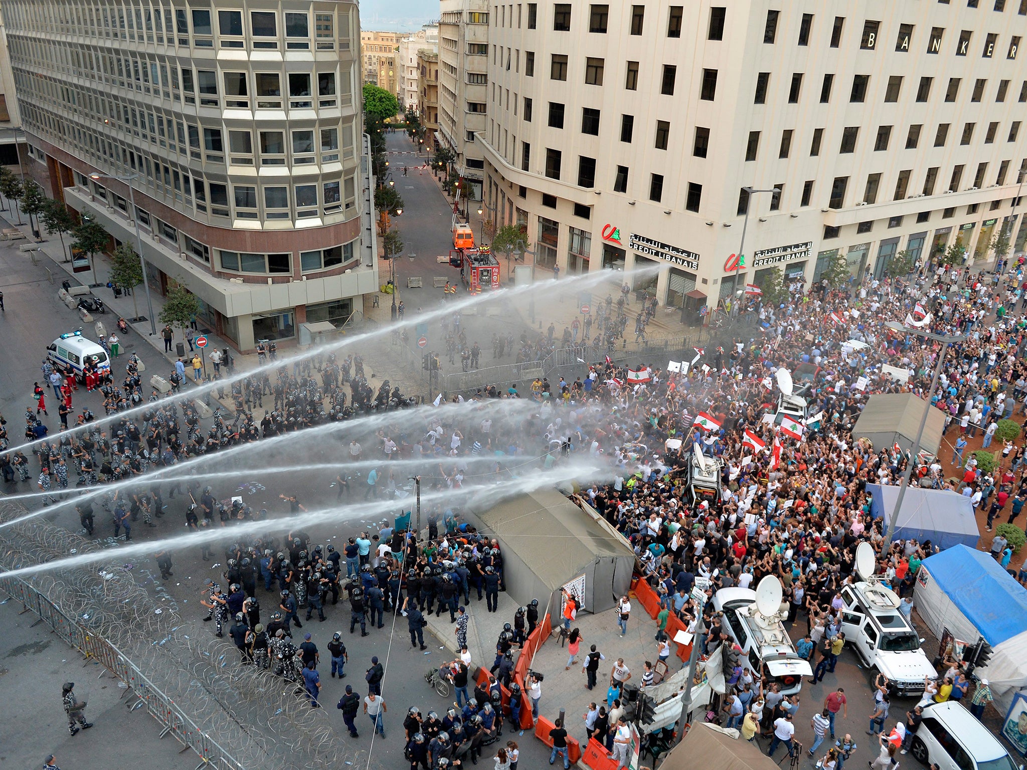 Lebanese security services use water cannons to disperse activists trying to remove barbed wire blocking the entrance to the Lebanese Government Palace