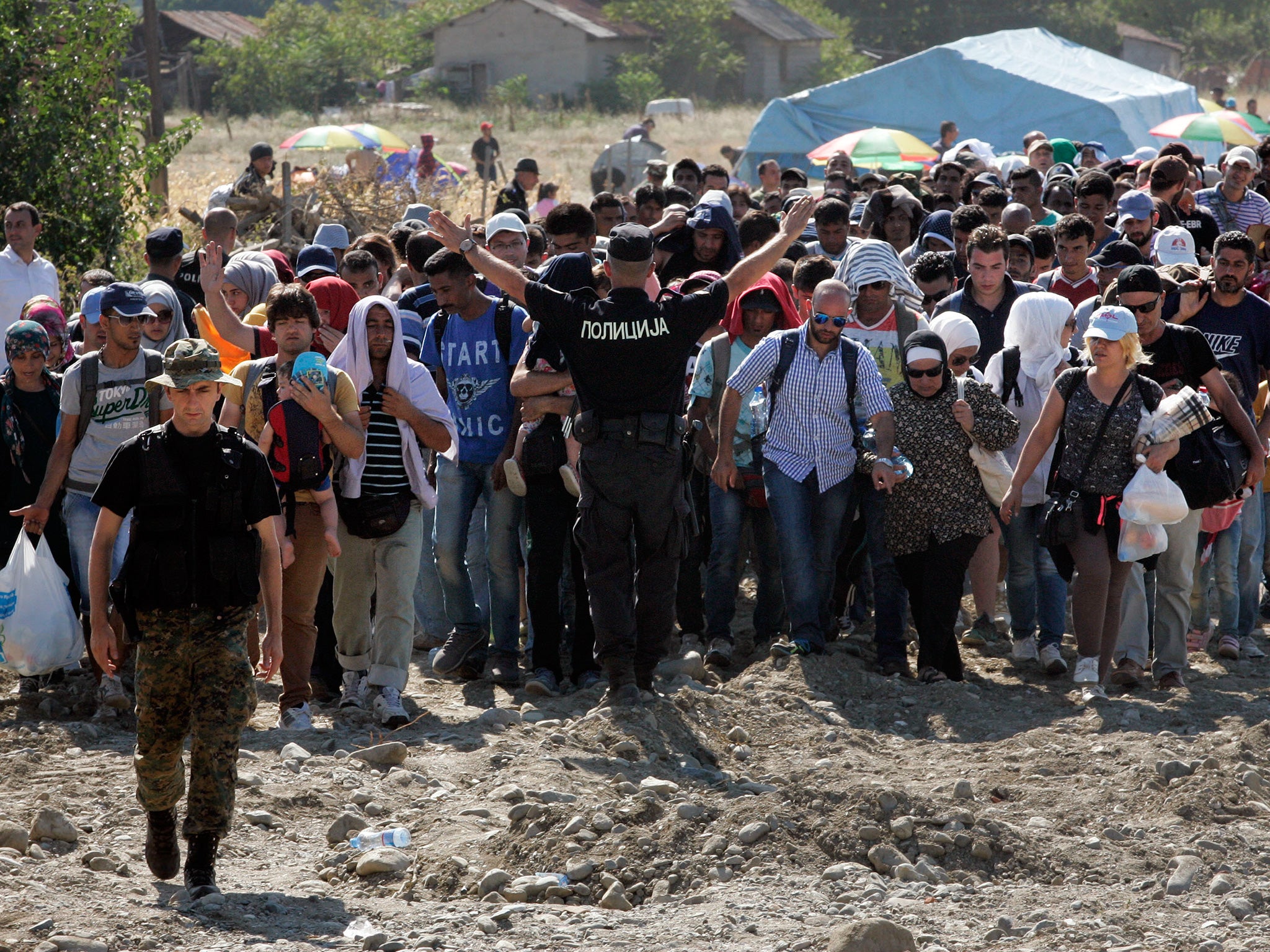 Migrants wait at a construction site where the Macedonian goverment is builiding a new reception centre