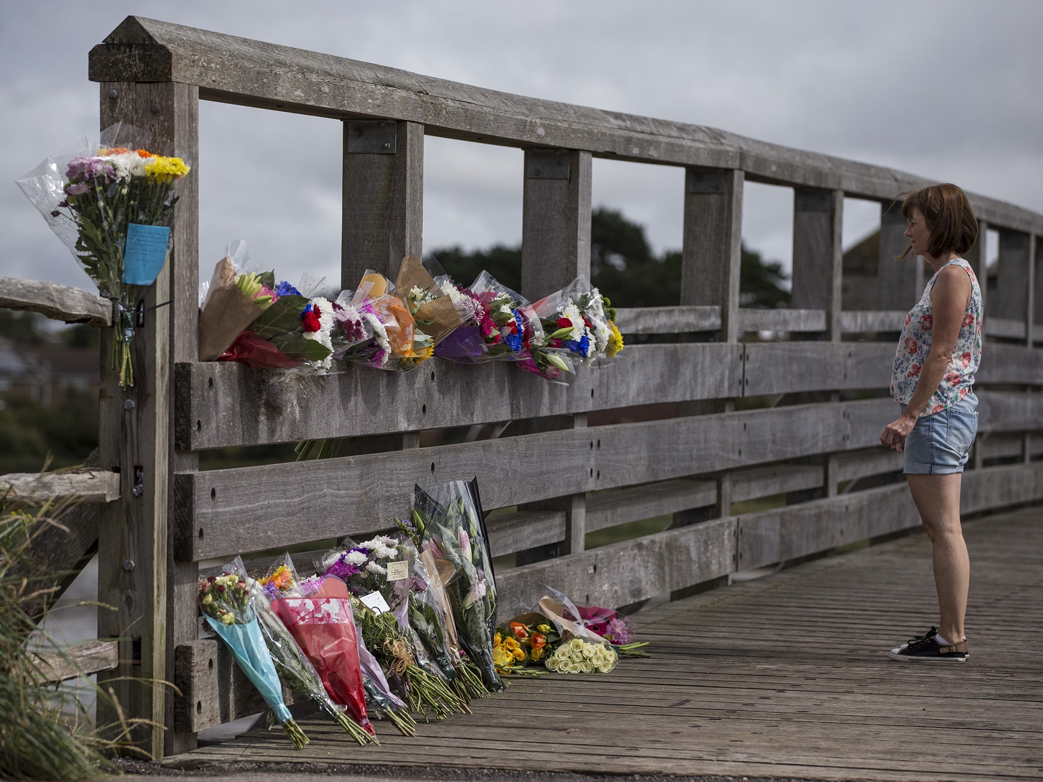 A woman lays flowers near the site where a Hawker Hunter fighter jet crashed on August 23, 2015 in Shoreham, England