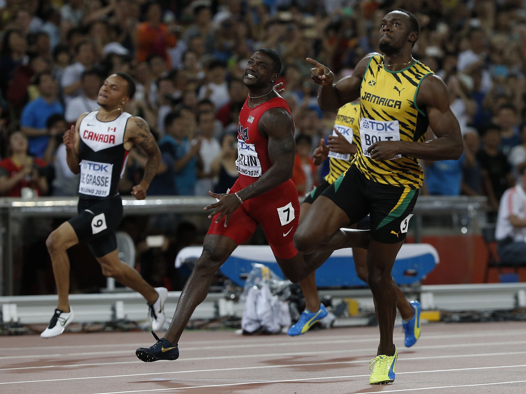 Jamaica's Usain Bolt (R) reacts as he crosses the finish line ahead of USA's Justin Gatlin