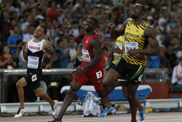 Jamaica's Usain Bolt (R) reacts as he crosses the finish line ahead of USA's Justin Gatlin 