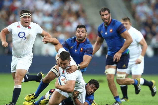 Nick Easter of England is tackled by Damien Chouley and Noa Nakaitaci at Stade de France on Saturday