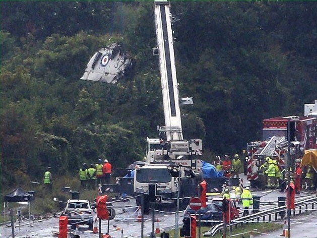 A crane removes part of the Hawker Hunter fighter jet from the side of the road in Shoreham
