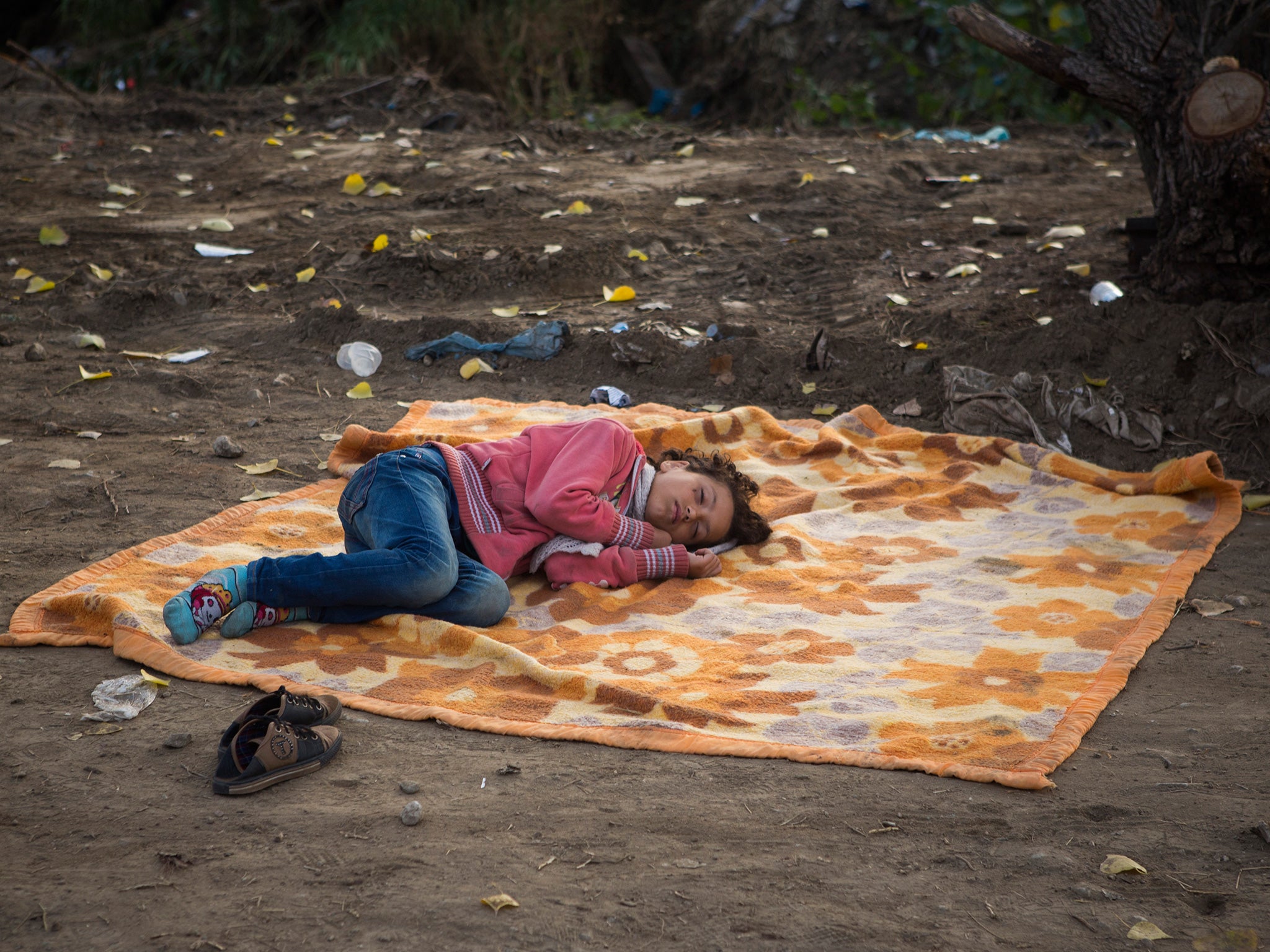 A Syrian refugee sleeps on a site near the railway station of Idomeni, northern Greece while she waits with her family to cross the border and enter Macedonia