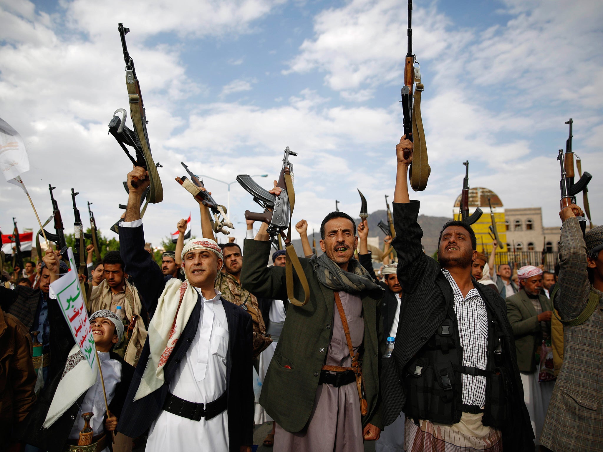 Houthis hold up their weapons as they chant slogans during a rally against Saudi-led airstrikes in Sanaa