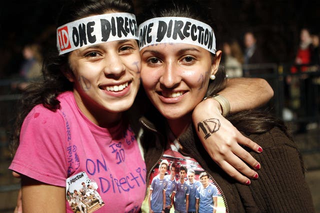 Two Directioners pose for a photo at a One Direction concert in Uruguay, 2014