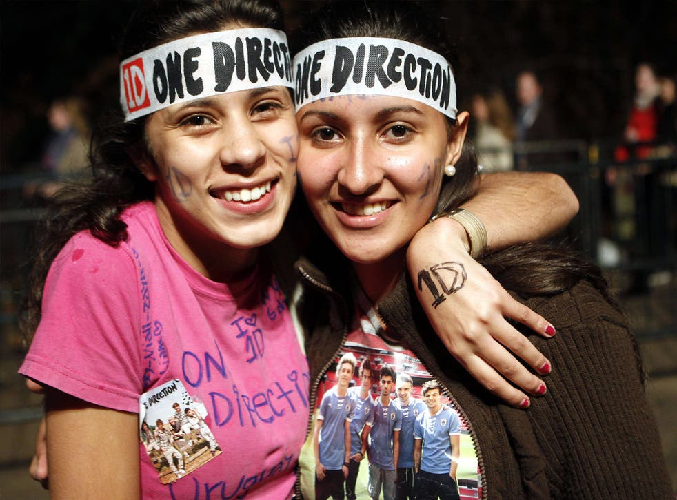 Two Directioners pose for a photo at a One Direction concert in Uruguay, 2014
