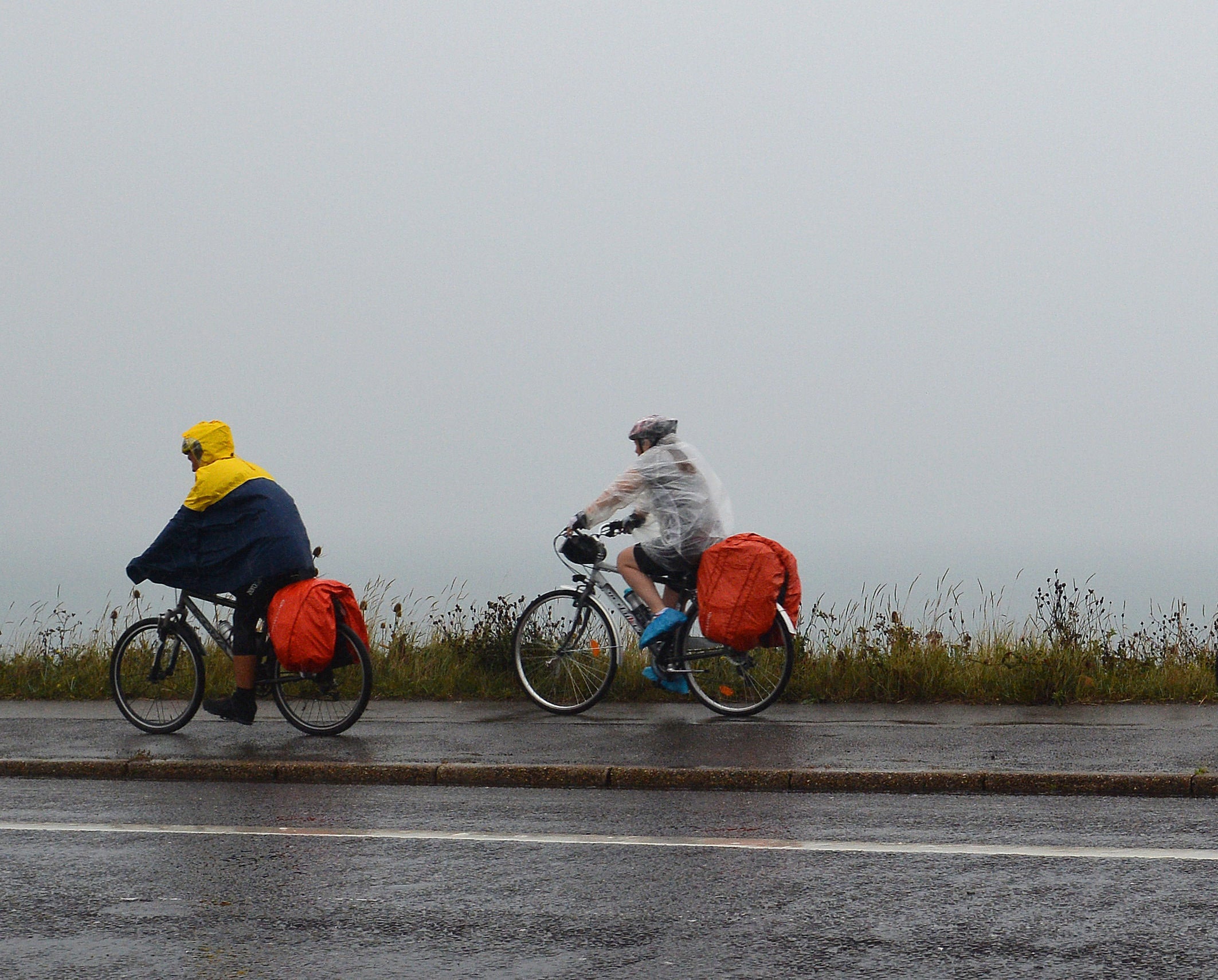 Cyclists battle the elements on the south coast as heavy rains sweep across the South West of England