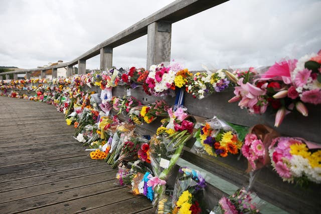 Floral tributes to victims of the crashed Hawker Hunter fighter jet line a bridge in Shoreham