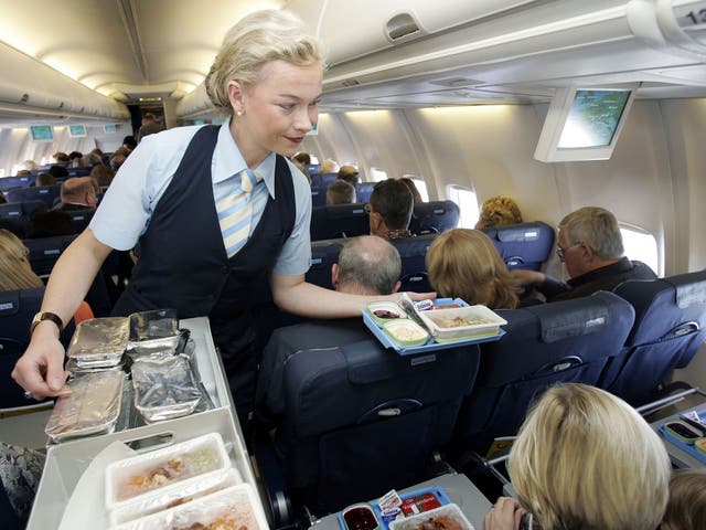 Flight attendant hands out food to passengers