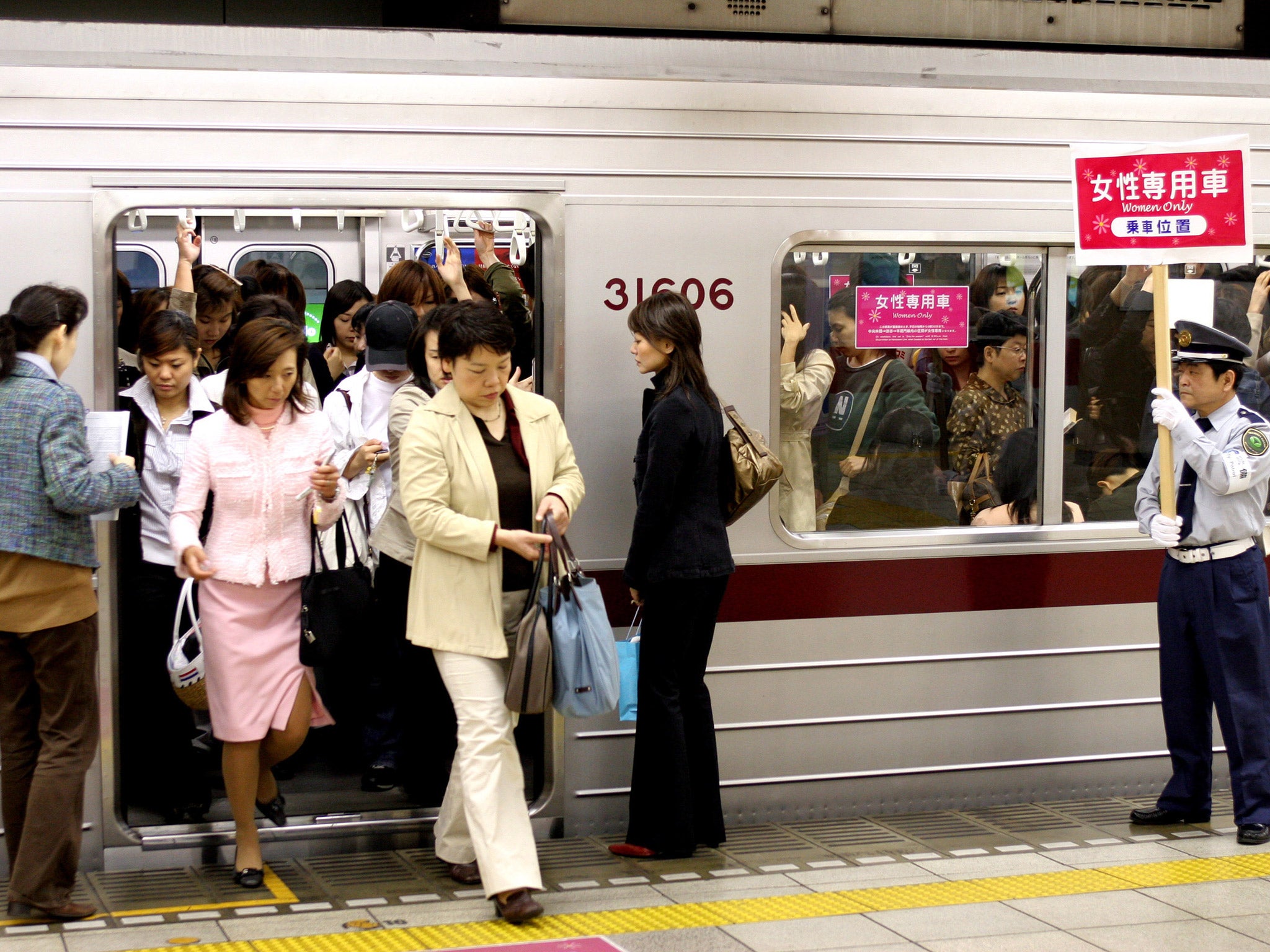 Female passengers come out from a 'women only' carriage at a metro station in Tokyo, Japan