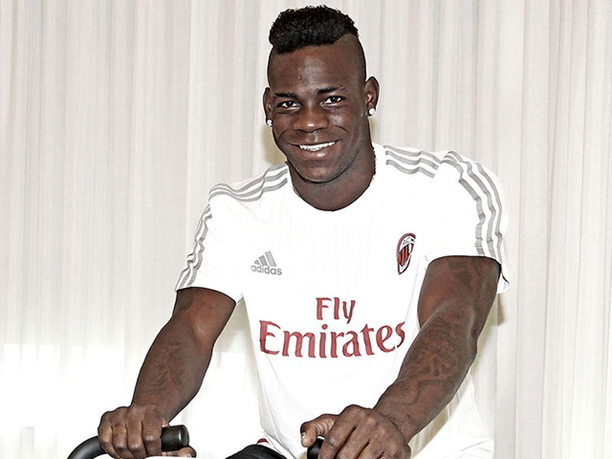 Mario Balotelli is all smiles at AC Milan's training ground as he closes in on switch