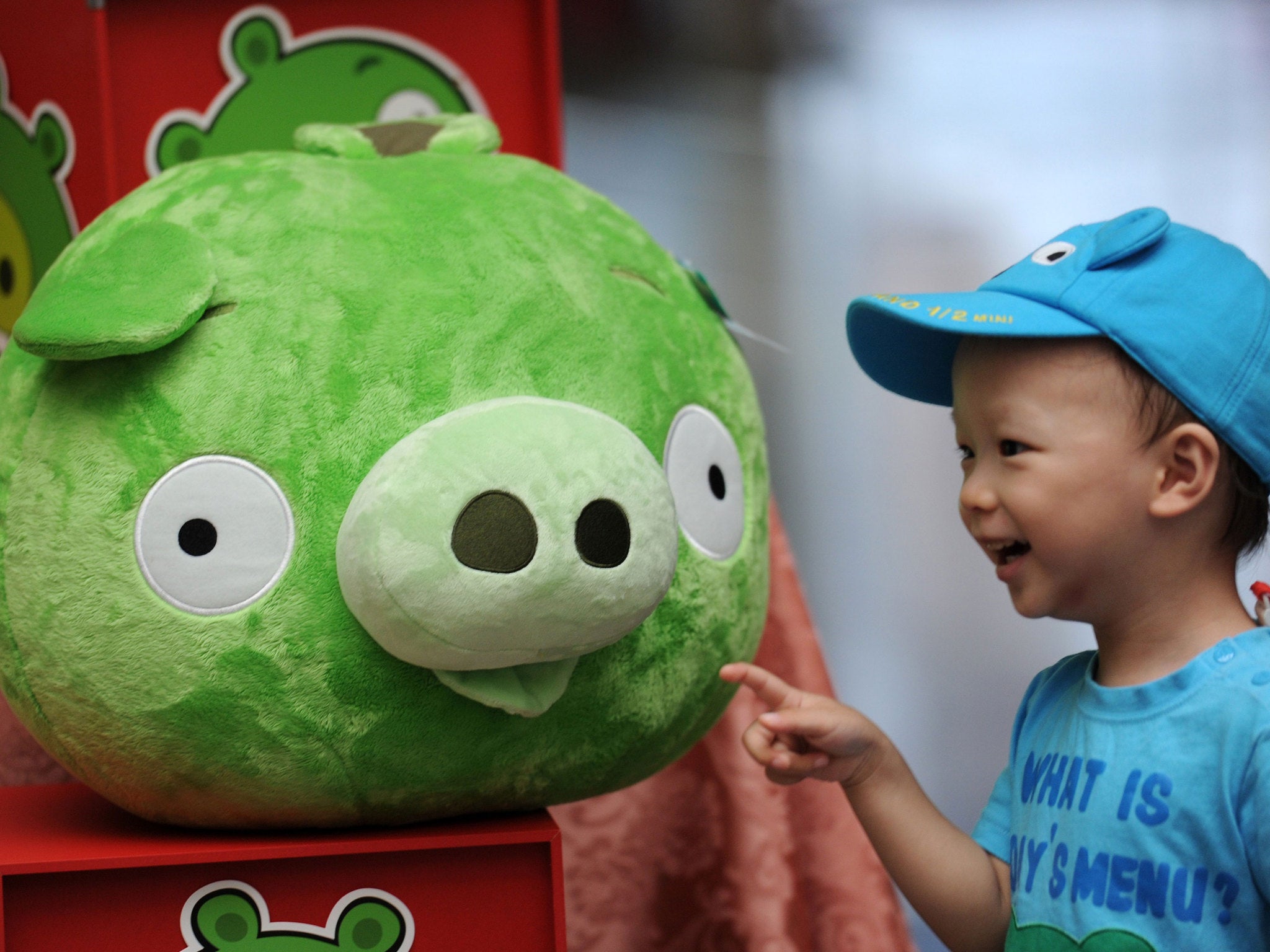A child touches a Bad Piggies stuffed toy from the Angry Birds game during a press conference in Taipei on September 27, 2012
