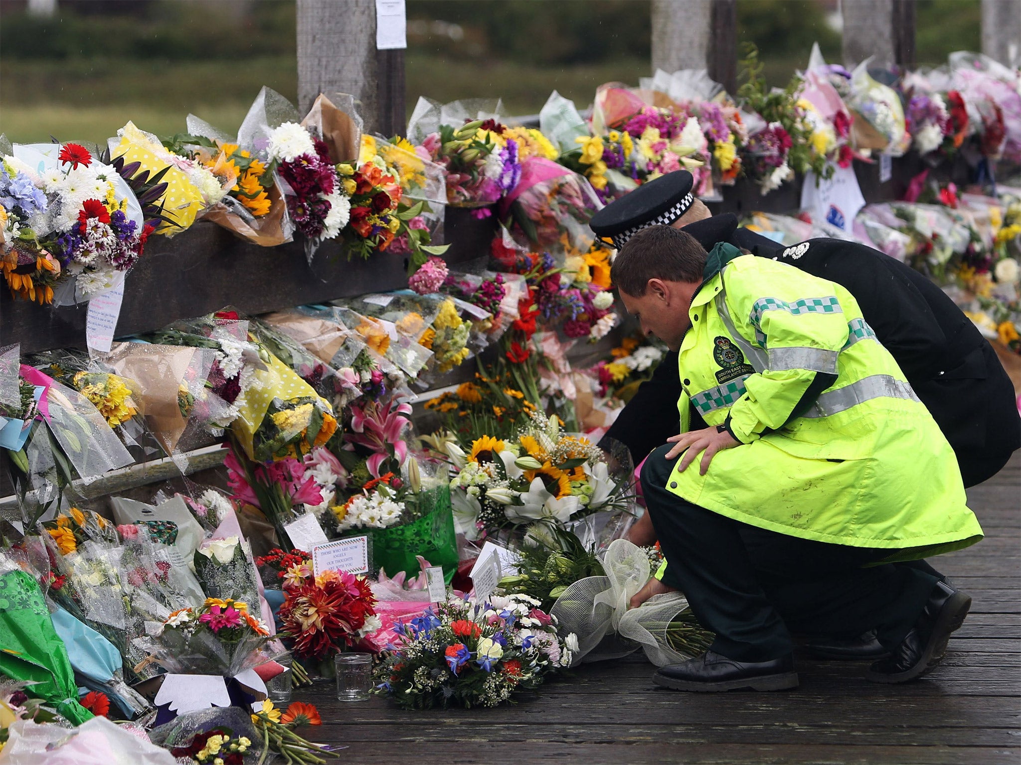 Floral tributes are left by representatives of the emergency services, close to the scene of the disaster