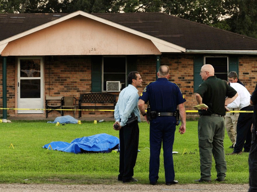 Law enforcement investigators investigate the scene of a stabbing and shooting at a home in Sunset, Louisiana