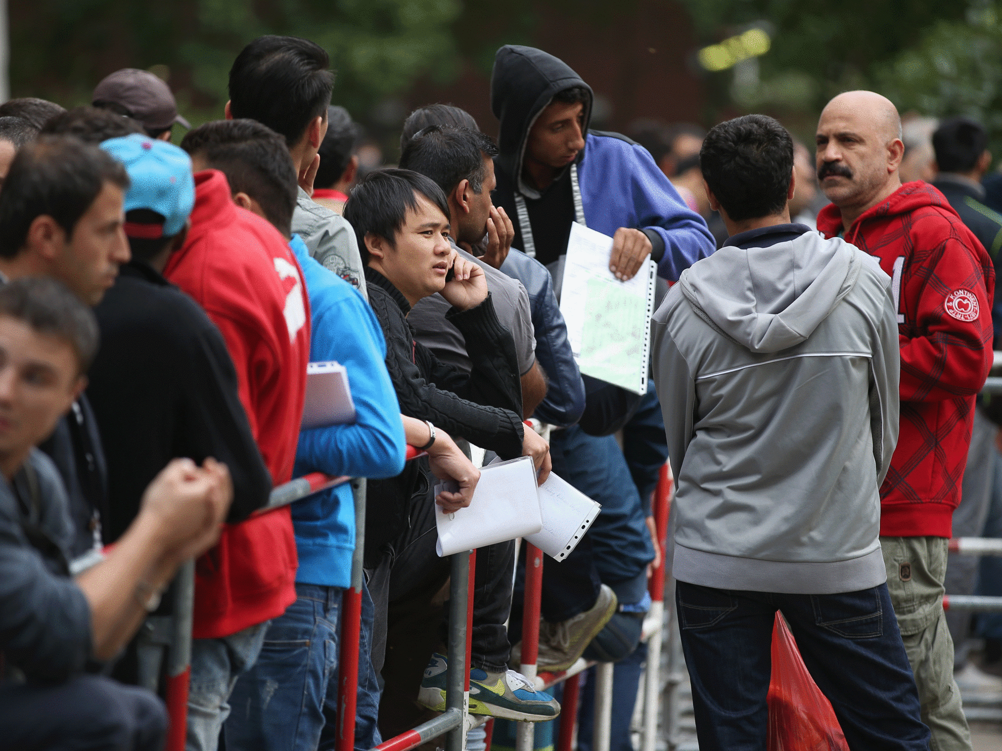 Migrants in Berlin wait to receive money for living expenses