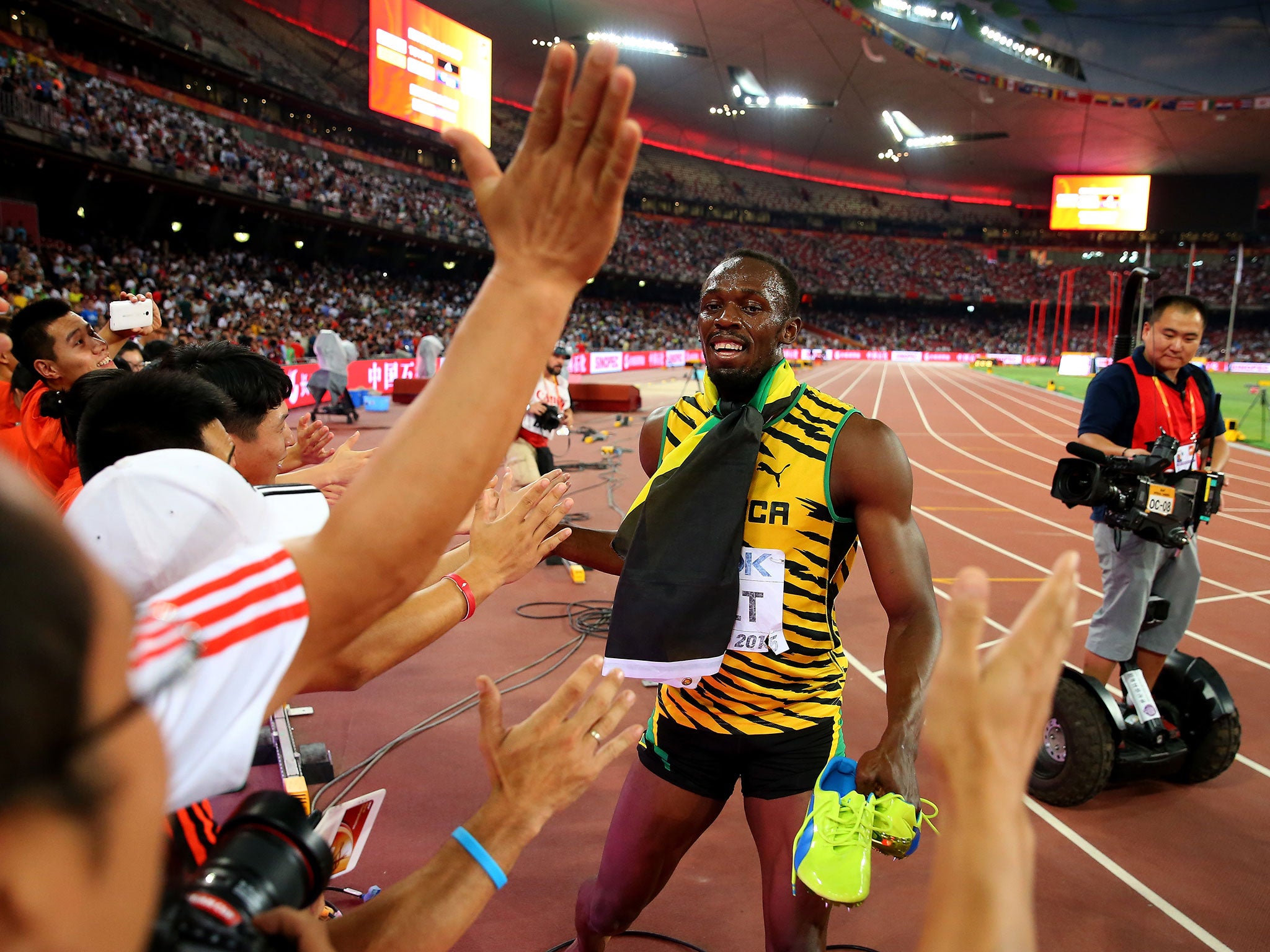 Usain Bolt celebrates as a cameraman follows him on a segway
