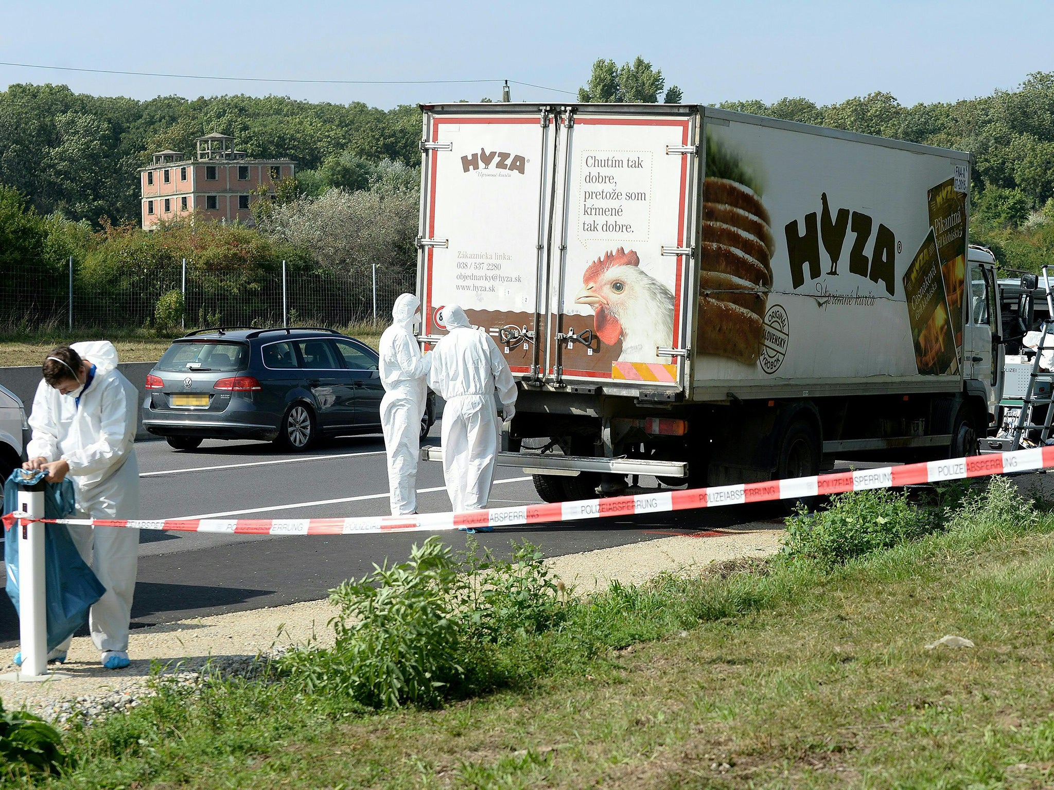 Forensic experts investigate a truck in which refugees were found dead as it stands on freeway autobahn A4 between Parndorf and Neusiedl, Austria