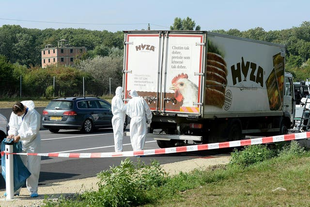 Forensic experts investigate a truck in which refugees were found dead as it stands on freeway autobahn A4 between Parndorf and Neusiedl, Austria