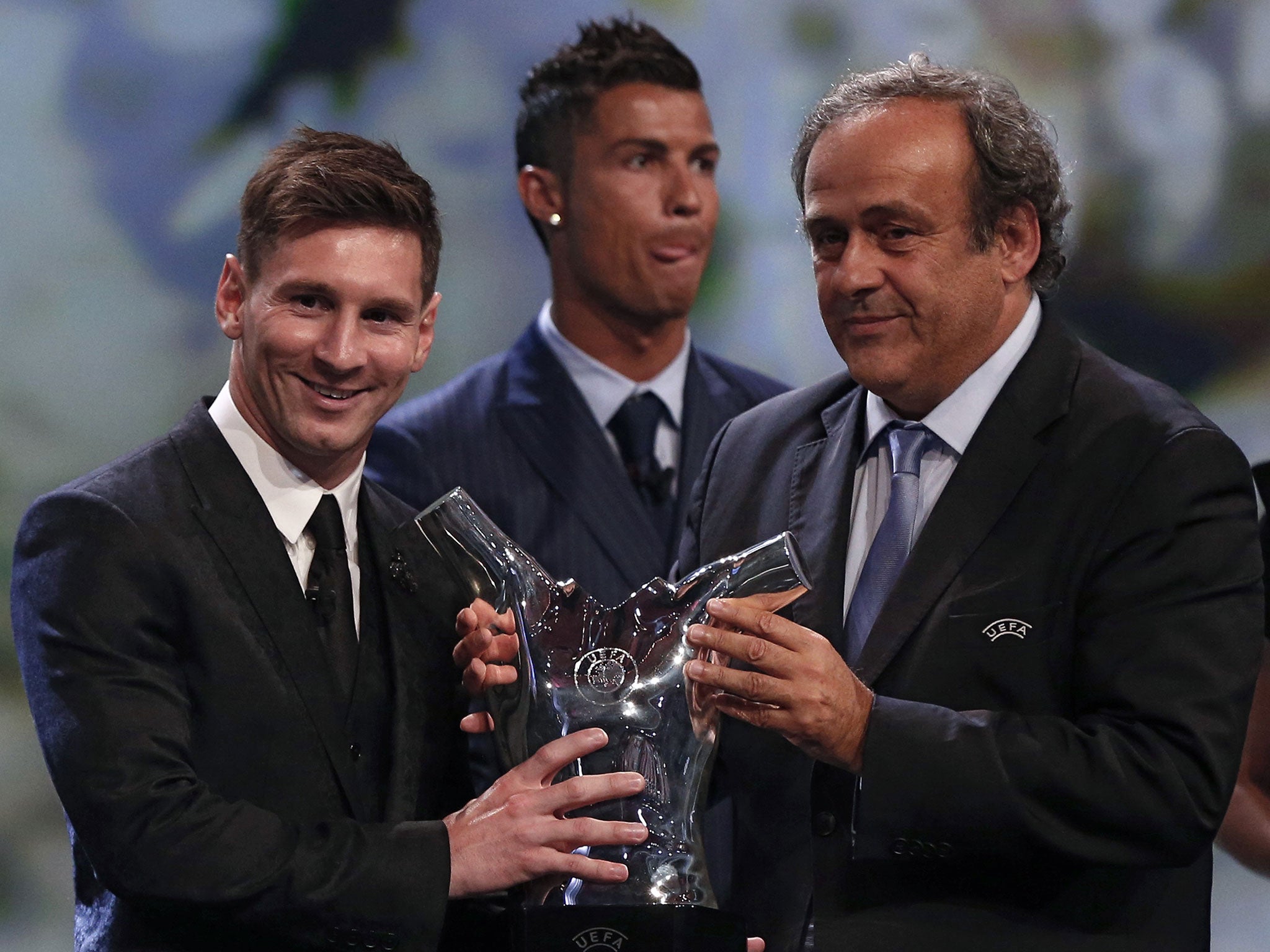 Platini presents Messi with the Player of the Season trophy as Ronaldo looks on