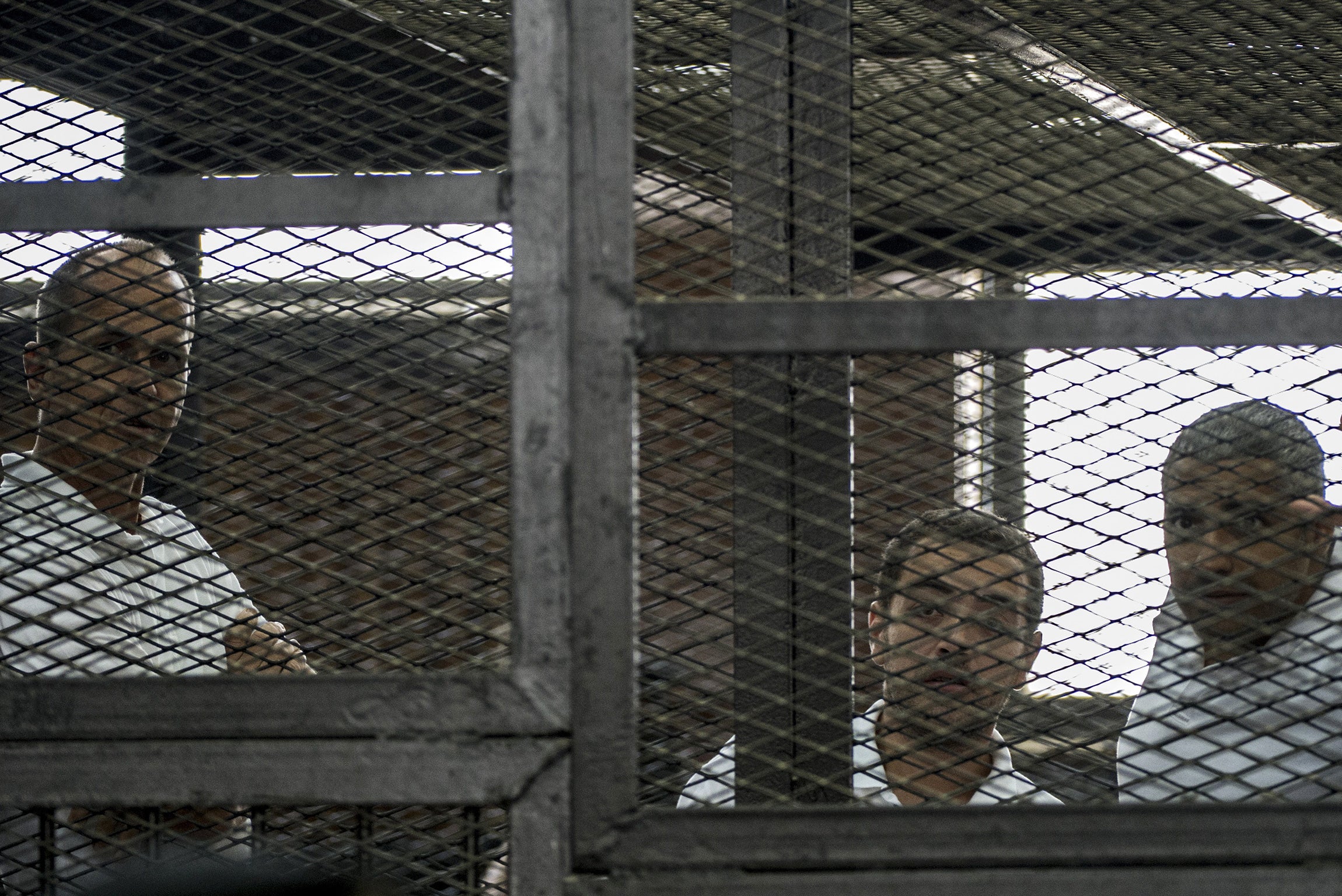 Peter Greste (left) and Mohamed Fahmy flank Baher Mohamed during their initial trial in June 2014 for ‘supporting the Muslim Brotherhood’