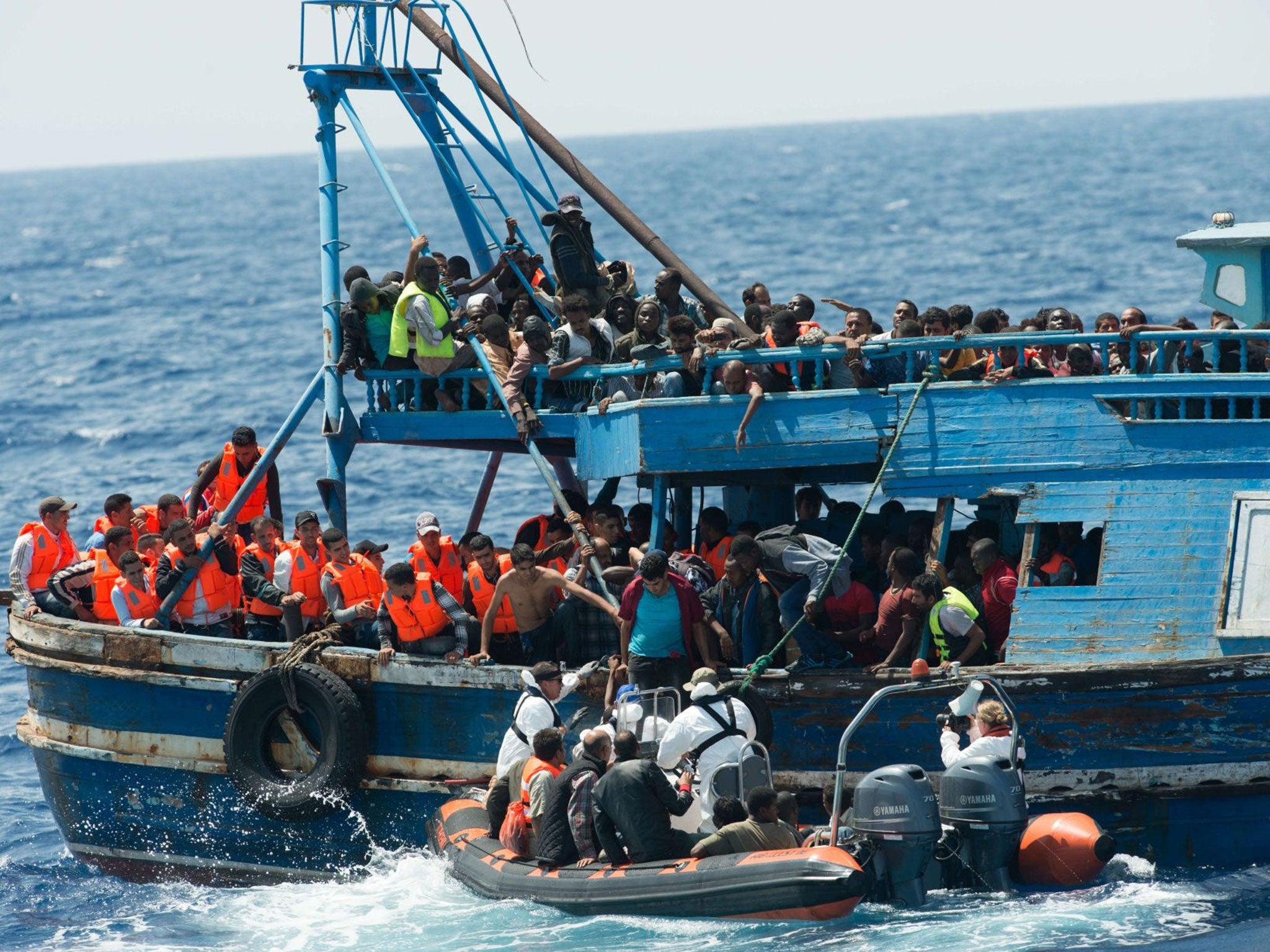 This handout picture released by the French NGO Medecins Sans FrontiËres (Doctors without borders - MSF) on August 27, 2015 shows migrants on a wooden boat during a rescue operation by MSF and the Swedish Coast Guards "Poseidon" in the Meditterranean sea