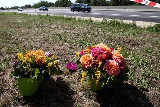 Flowers and candles are placed at the site where a refrigerated truck with decomposing bodies was found by an Austrian motorway 