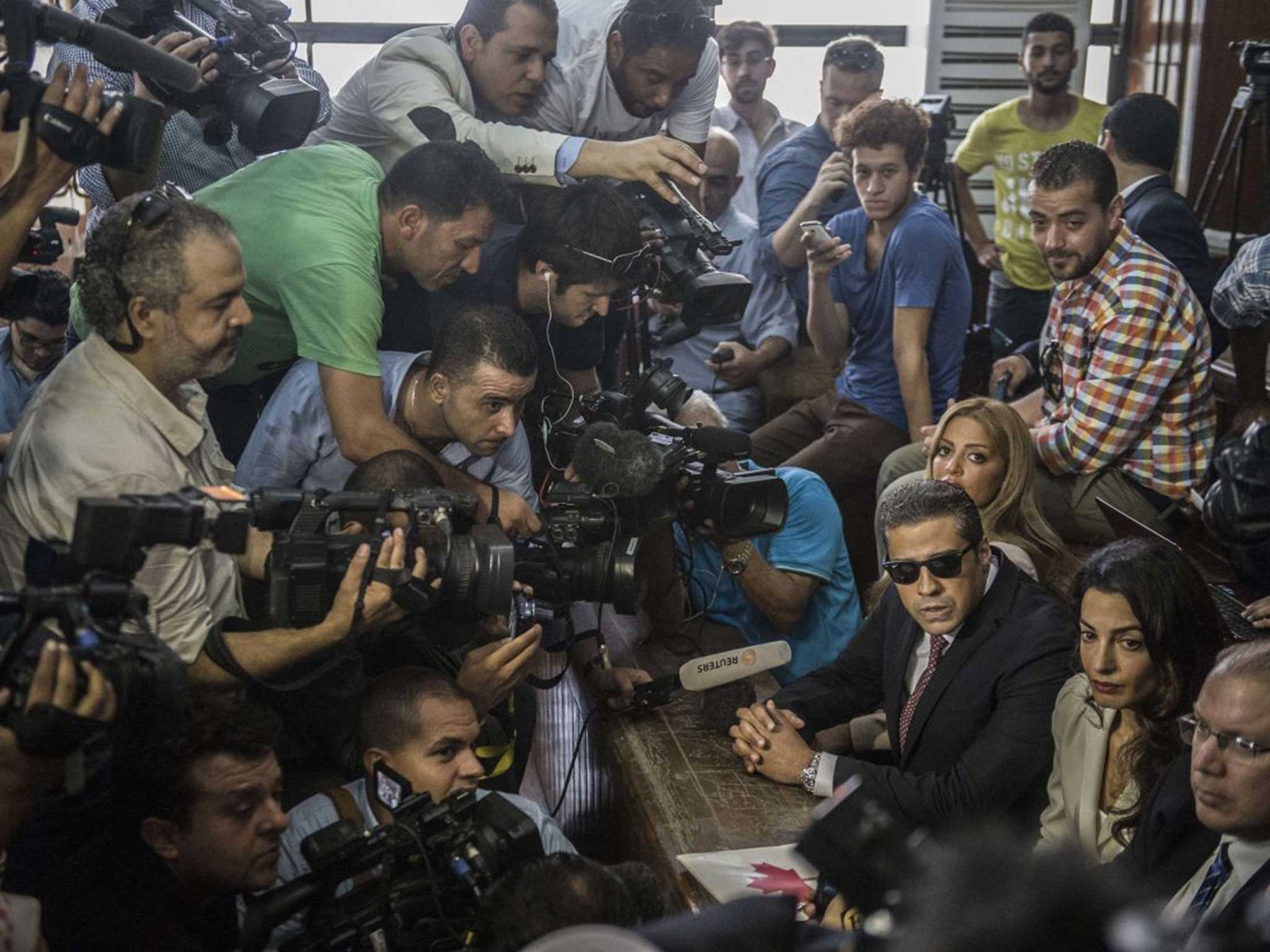 International media forms a scrum around Mohammad Fahmy, wife Mawra and their lawyer Amal Clooney in the court
