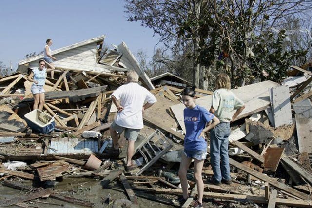 Residents look at their house after it was destroyed by Hurricane Katrina 30 August 2005 (AFP)