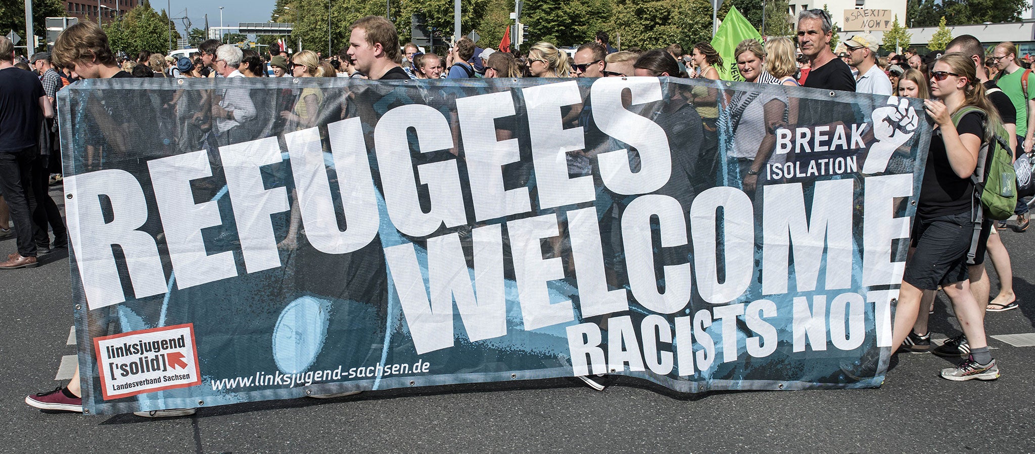 Protesters demonstrate with a banner saying 'Refugees welcome' in Dresden, eastern Germany, on Saturday 29 August