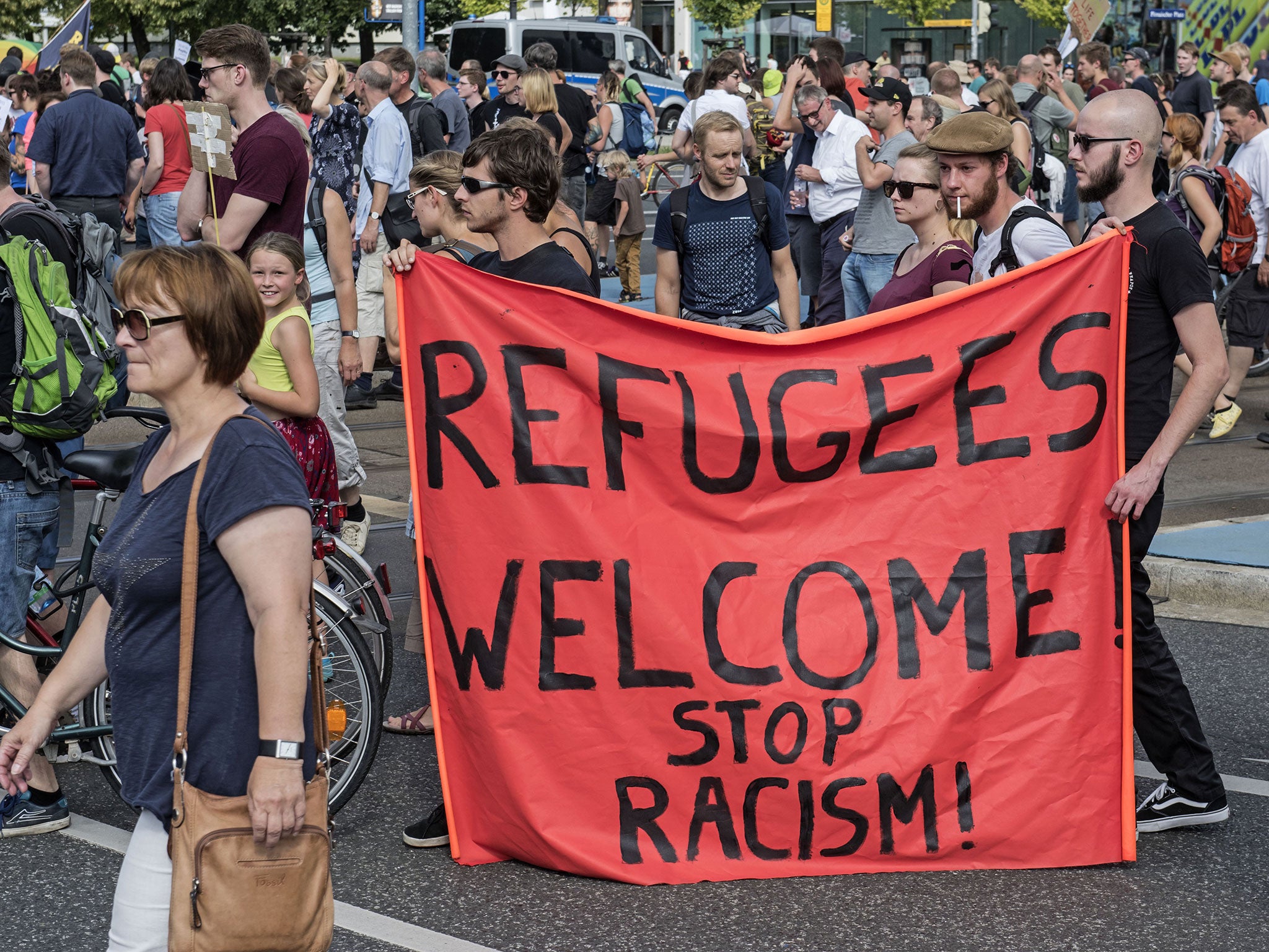 Protesters demonstrate with a banner saying 'Refugees welcome' in Dresden, eastern Germany, on Saturday 29 August