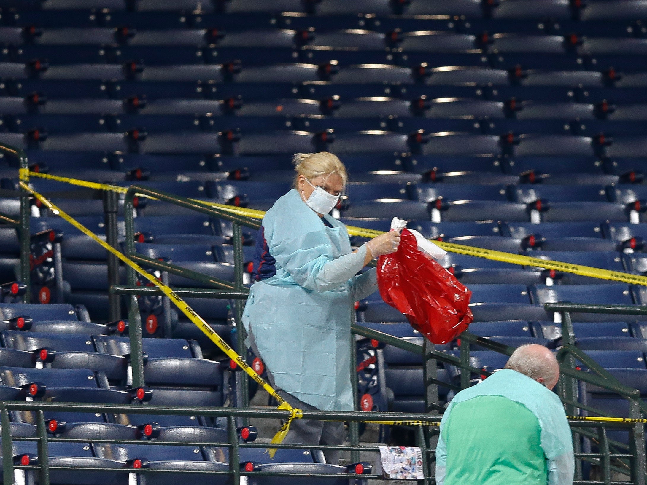 People clean a section of the lower seating area at Turner Field where the fan fell