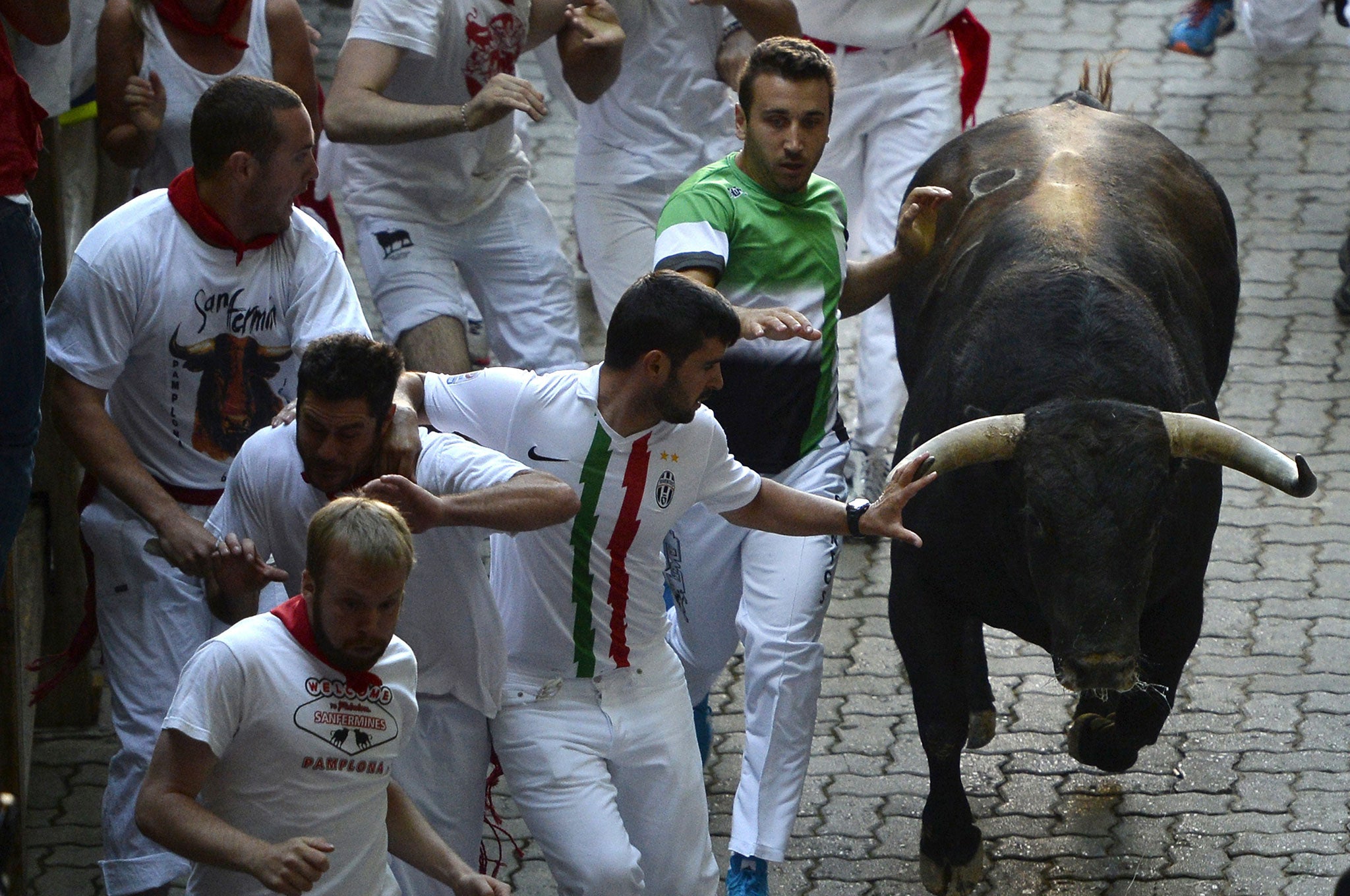 Participants run in front of Fuente Ymbro's bulls during the fourth 'encierro' (bull-run) of the San Fermin Festival in Pamplona