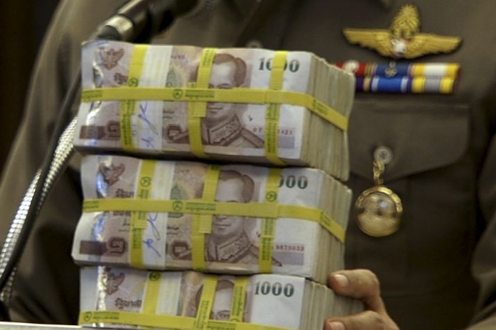 In this image taken from video, National police chief Somyot Poompanmoung holds a cash reward at a press conference in Bangkok, Thailand, Monday, Aug. 31, 2015. Thai police have awarded themselves a 3 million baht ($84,000) reward offered to the public fo