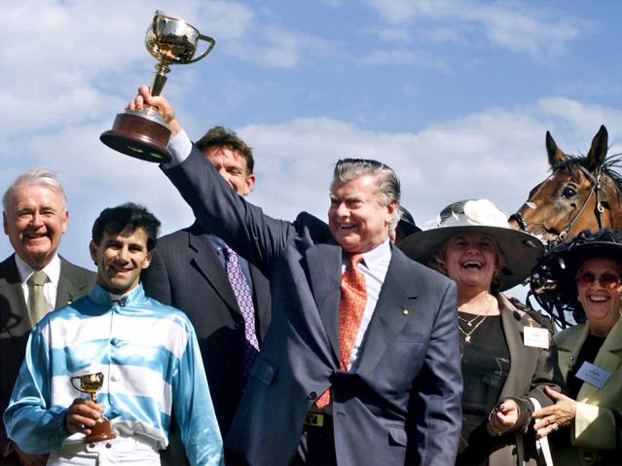 Cummings lifts the Melbourne Cup for the 11th time, in 1999, following Rogan Josh's win