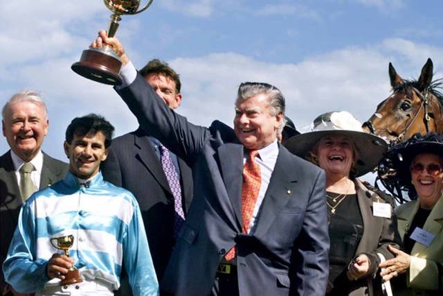 Cummings lifts the Melbourne Cup for the 11th time, in 1999, following Rogan Josh's win