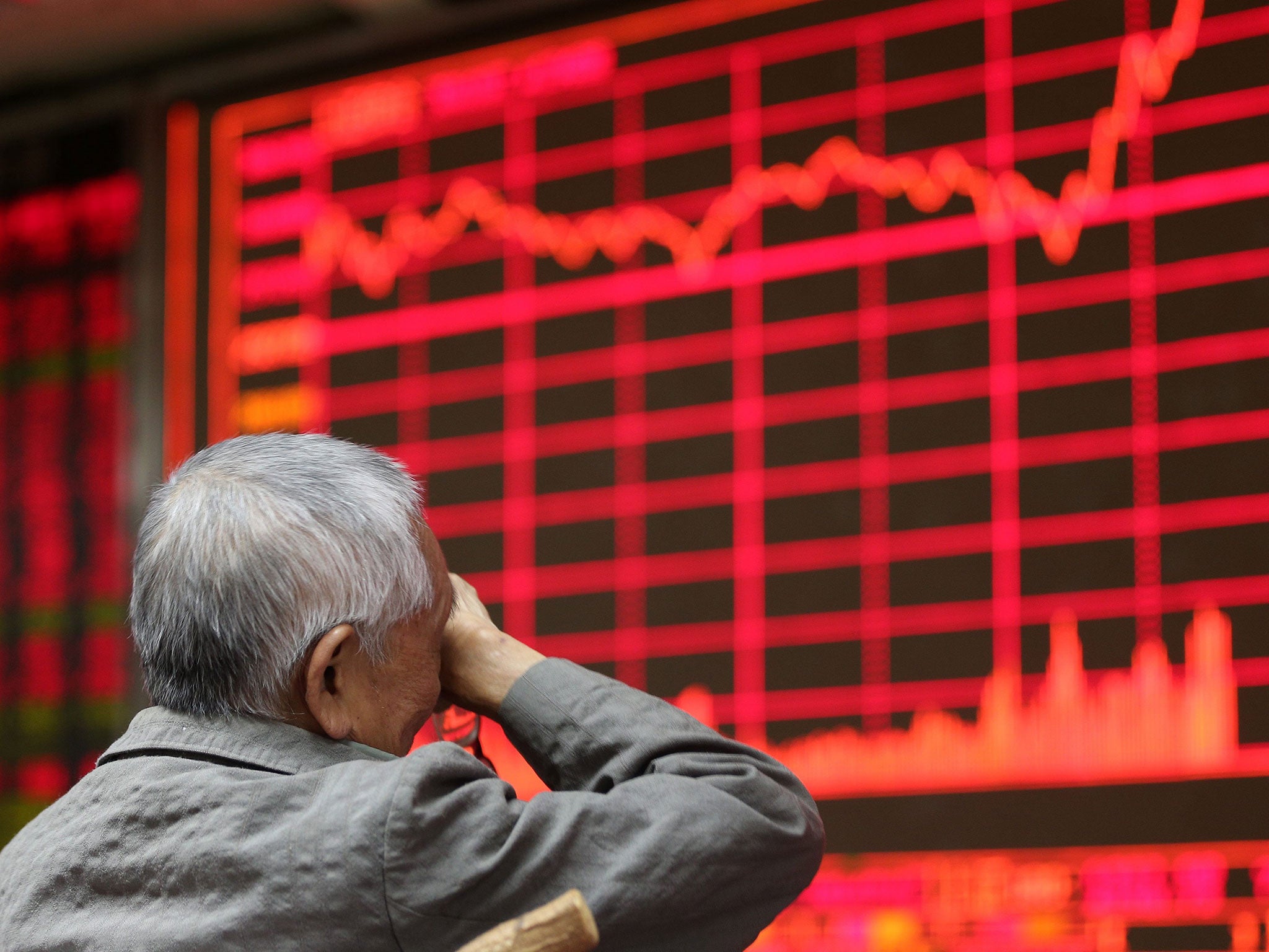 A stock investor sits in front of an electronic screen showing the stock composite index at a brokerage house in Beijing, China, 27 August 2015