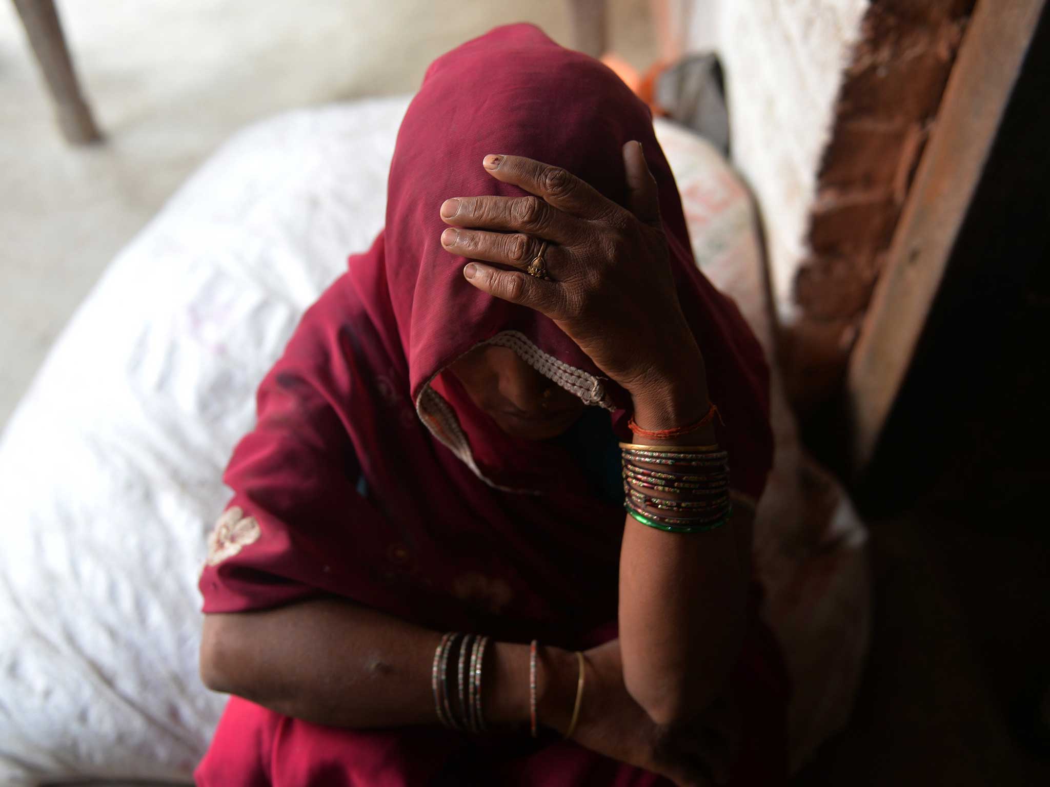 An Indian woman hides her face: in Baghpat villager, locals deny the sisters' tale