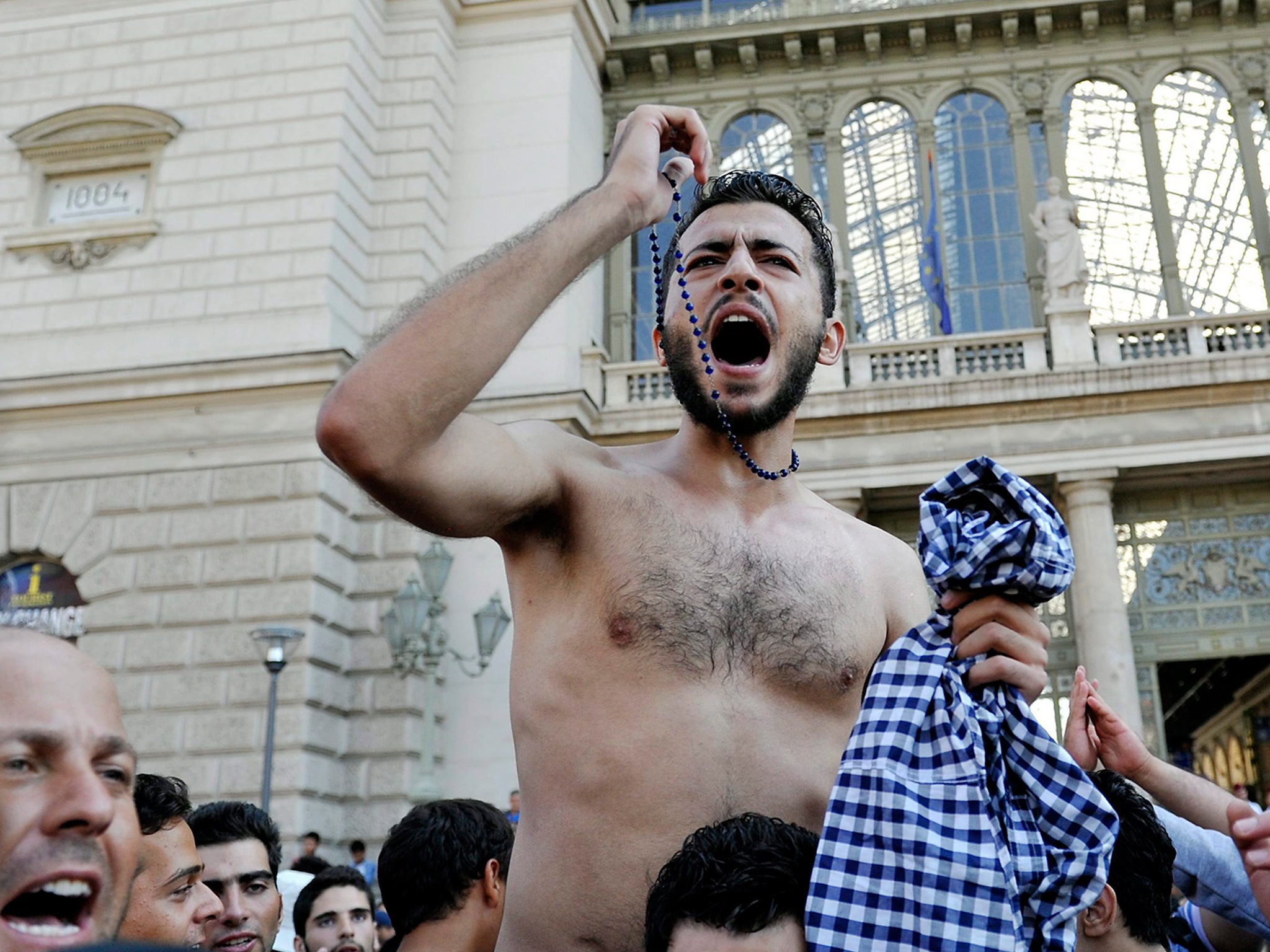 Migrants shout slogans in front of the Keleti Railway Station