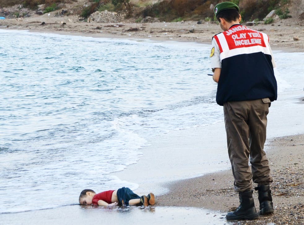 A young Syrian boy, who drowned in his family’s attempt to reach Greece from Turkey, lies in the surf near Bodrum, Turkey