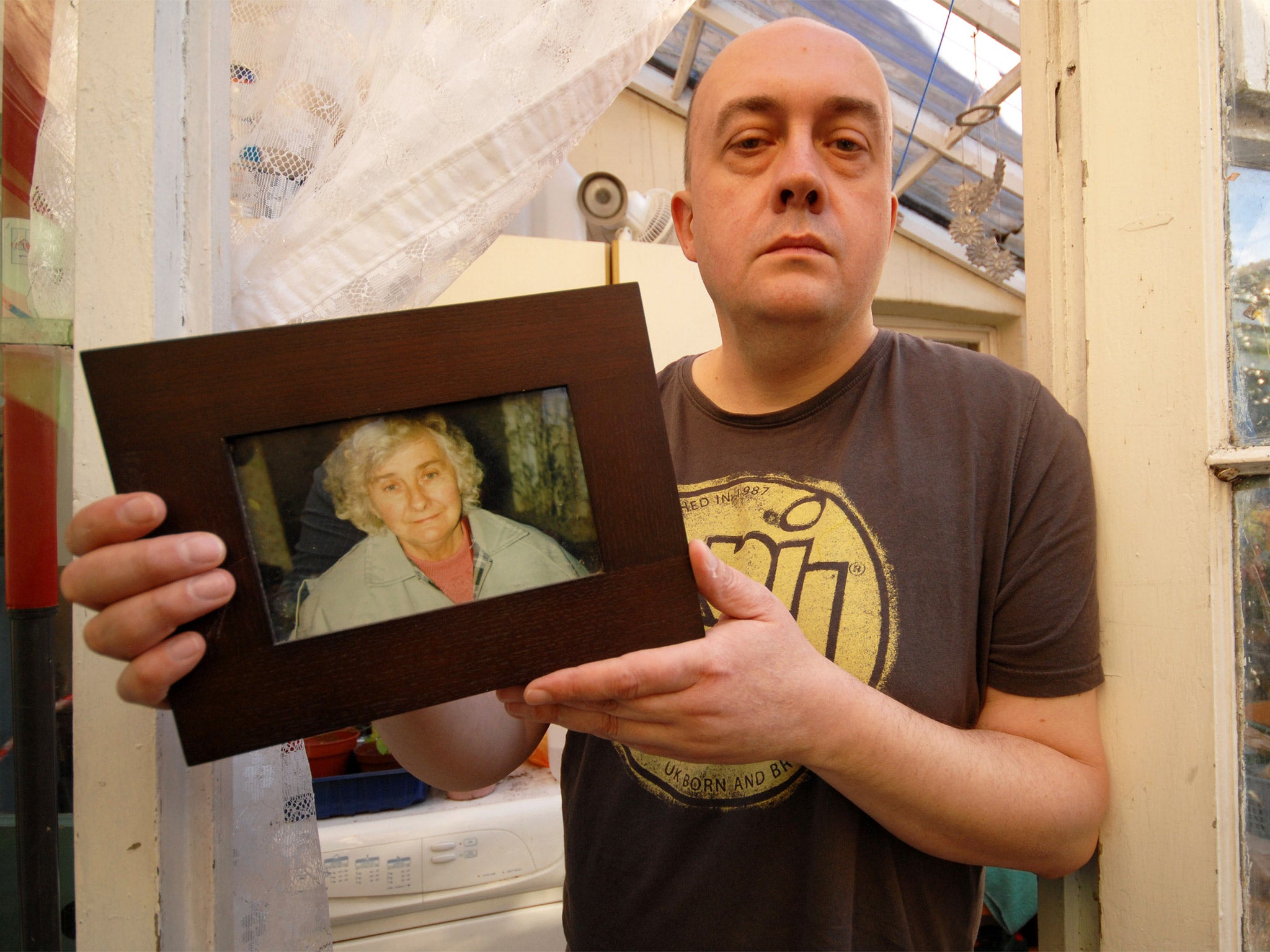 Simon Cooke with a picture of his mother, Barbara, who died days after being admitted to hospital from her care home