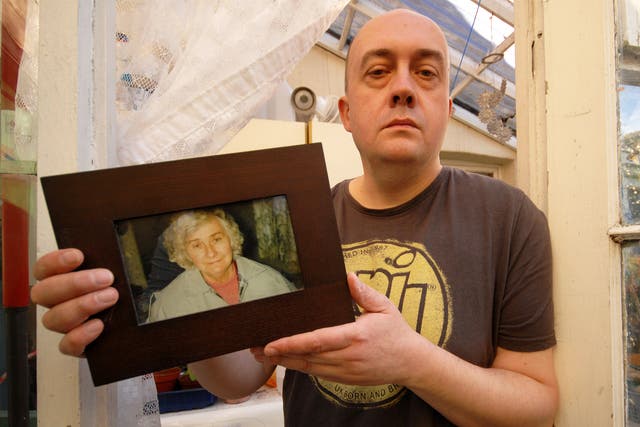 Simon Cooke with a picture of his mother, Barbara, who died days after being admitted to hospital from her care home
