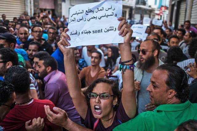 Demonstrators rally in Tunis on Tuesday against a planned financial amnesty for members of former President Zine el-Abidine Ben Ali’s regime. Some protesters were beaten up and arrested