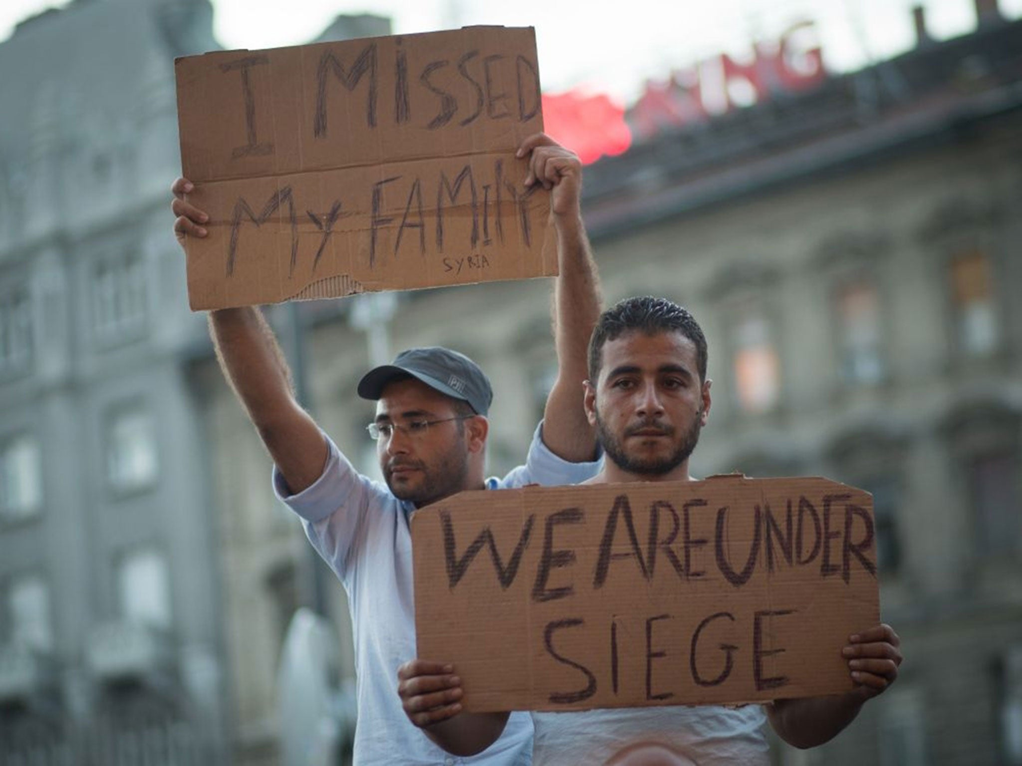 Men protest outside Keleti station (Image: Reuters)