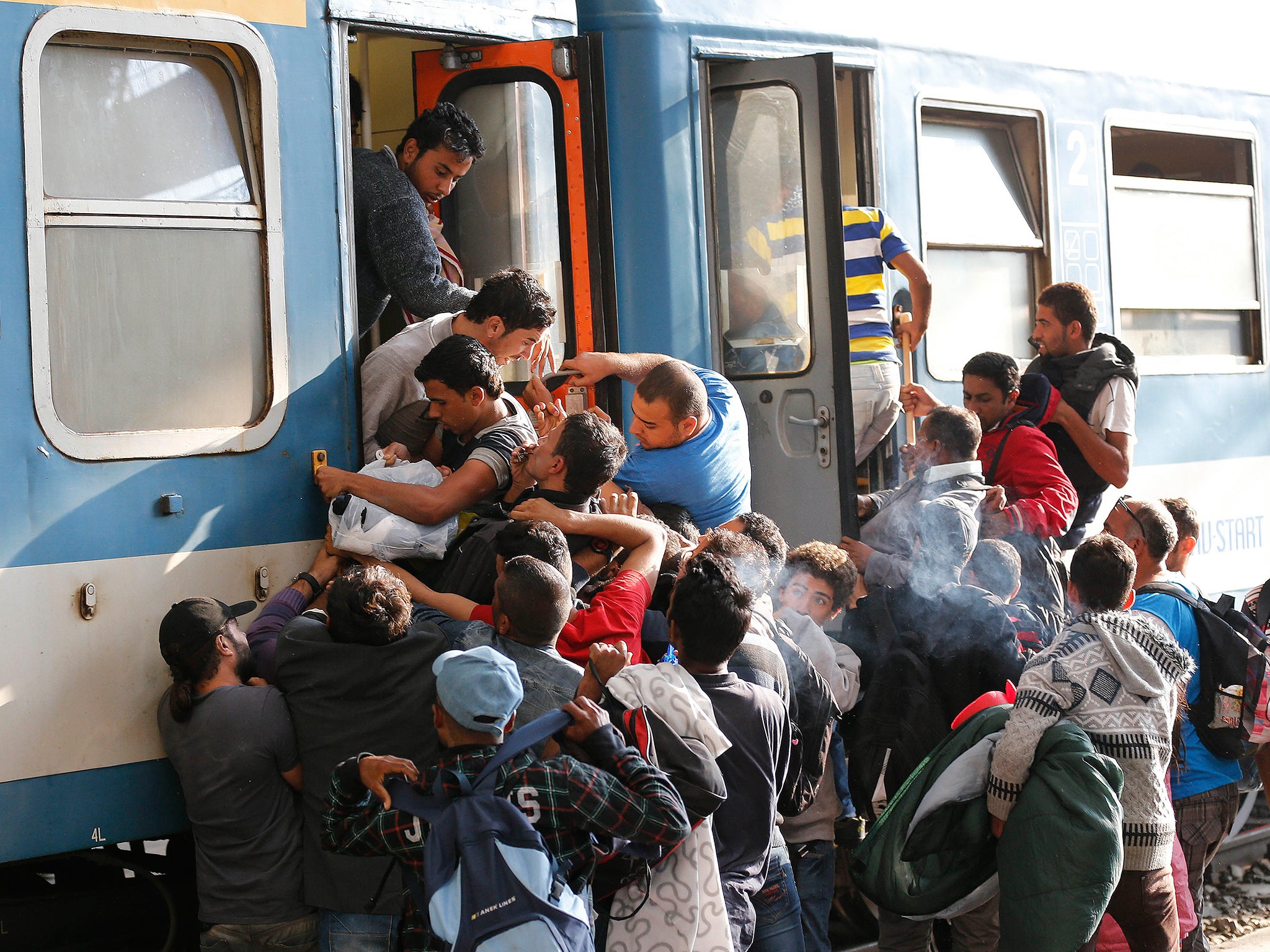 People struggle to board a train at the railway station in Budapest