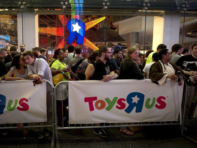 People line up outside a Toys R Us store just before midnight to purchase toys in advance of the film "Star Wars: The Force Awakens" in Times Square in the Manhattan borough of New York, September 3, 2015.