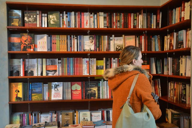 A woman browse a book shop, seeing what cover grabs her fancy